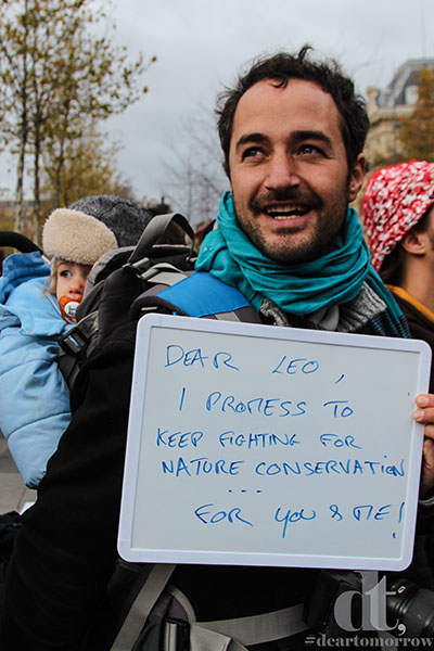 Image of man holding a marker board with a letter promising climate action