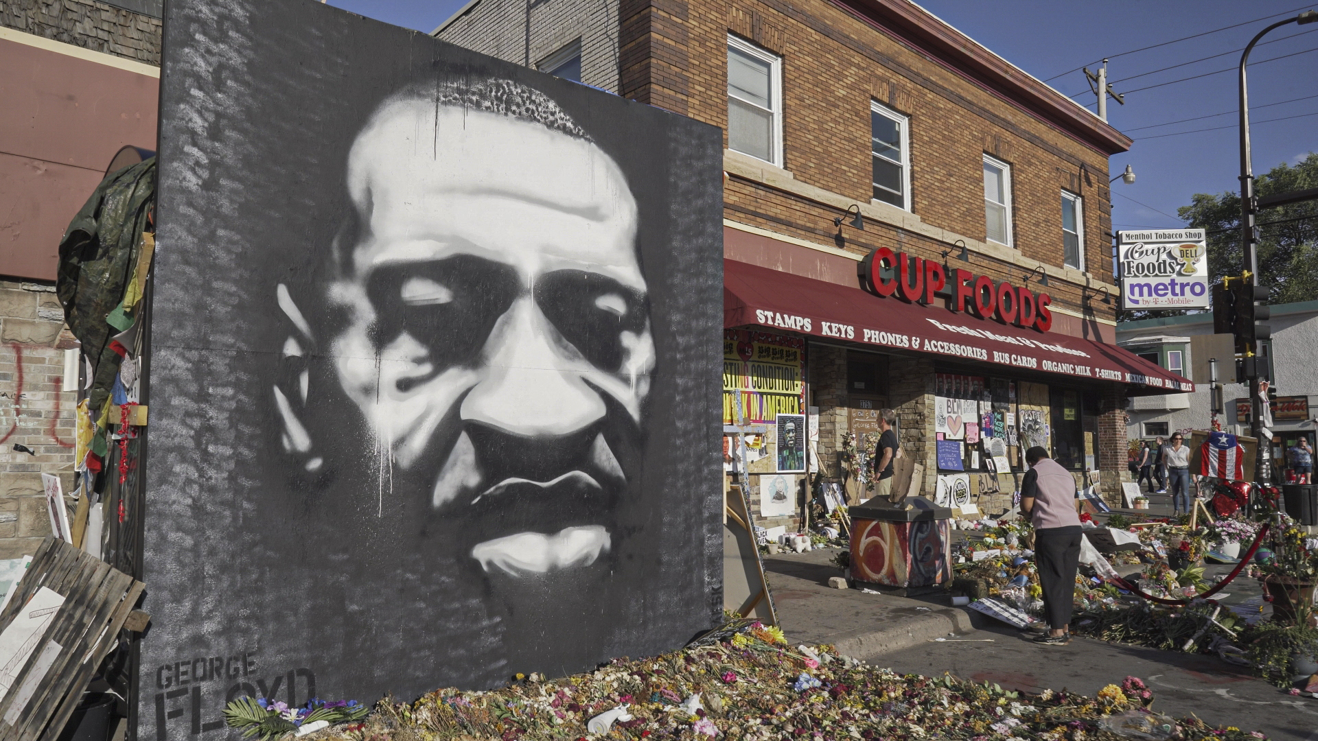 Mural of George Floyd's face next to street protest