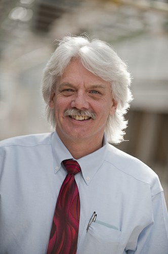 This is a photo of Larry Schardt. He is wearing a white shirt and red tie.