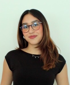 Photo of Edith Rivadeneira. A woman with shoulder-length brown hair wears glasses and a black formal sleeveless top with a chain necklace.